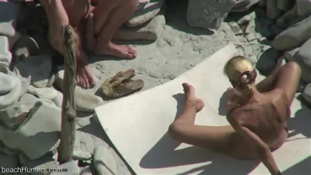 Blondynka gra z członkiem chłopaka na plaży nudystów
