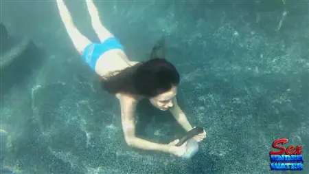 Dziewczyna pod wodą liże gumowe dildo