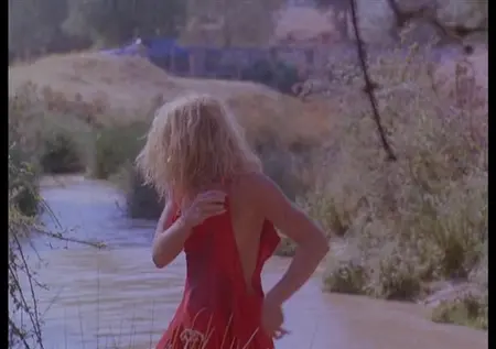Naga blondynka usuwa sukienkę w rzece