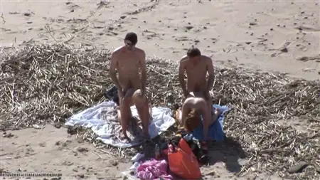 Tłum facetów na plaży wpuszcza w kręgu dwóch prostytutek